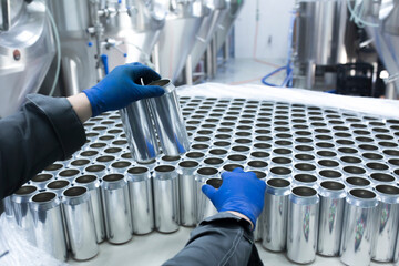 drink production manufactrure, worker's hand taking new aluminium cans
