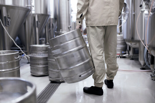 factory employee holding the metal aluminium beer keg