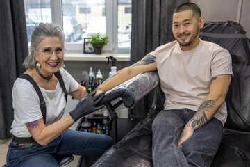 Tattoo master wotking on a tattoo for the male client