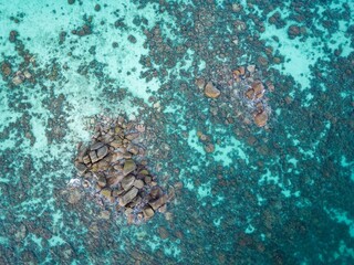 Top view of big rocks in the blue clear waters of the sea next to Ko Life island in Thailand