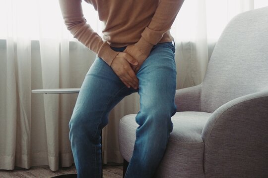 Man using his hands touching and covering his crotch suffering from his genitourinary system or genital organ problem Man healthcare and urinary incontinence concept