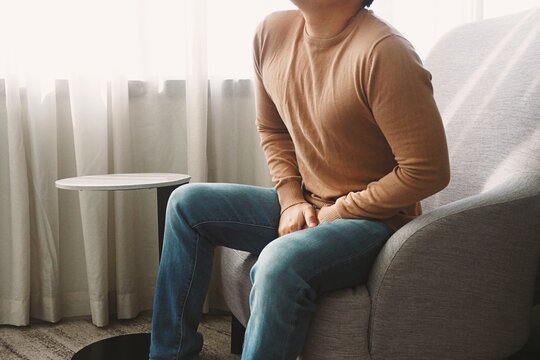 Man using his hands touching and covering his crotch suffering from his genitourinary system or genital organ problem Man healthcare and urinary incontinence concept