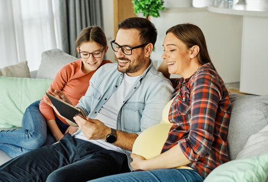 woman pregnant child man pregnancy family mother love tablet online communication father couple daughter girl happy husband baby wife belly