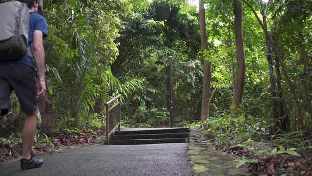 Young male hiker walking on a trail in Mount Faber Park in Singapore