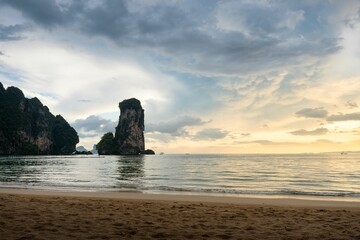 Naklejka premium Huge stack at the Pai Plong Beach with sunset and the horizon in the background in Krabi, Thailand