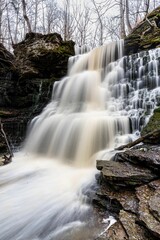 Obraz premium Long exposure shot of a cascade waterfall in the forest on a gloomy day