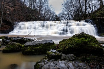 Obraz premium Long exposure shot of a cascade waterfall in the forest on a gloomy day