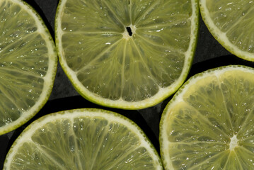 alcune belle fette di lime su sfondo scuro, foto macro alla texture delle fette di lime, il lime...