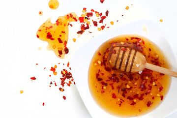 Hot honey or chili honey on white with loose chili flakes