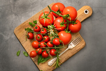 Cherry tomatoes and tomatoes on vine with herbs