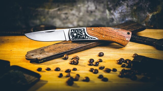 Opened pocket knife over a vintage ruler on the wooden surface