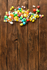 Colourful candies on wooden background with copyspace. Top view