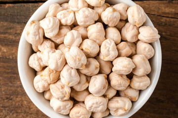 Chickpeas beans in bowl on rustic wooden table. Top view