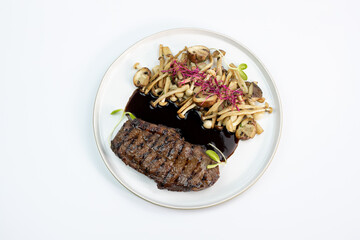 grilled beef steak in plate on white background. Top view