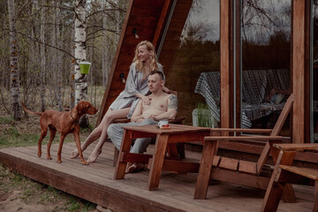 Beautiful couple and dog in the morning at the campsite on the porch