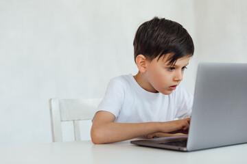 education online online games classes boy sitting at a laptop at school