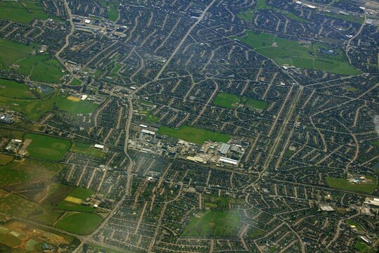 Aerial view of a residential area with green fields.