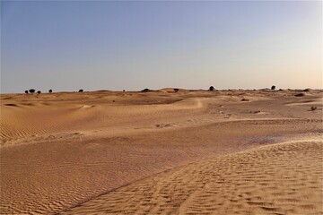 Scenic view of desert against sky under the clear blue sky with the sun shining bright