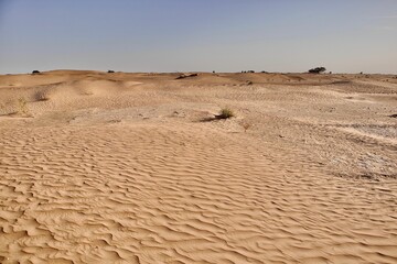 Scenic view of desert against sky under the clear blue sky with the sun shining bright