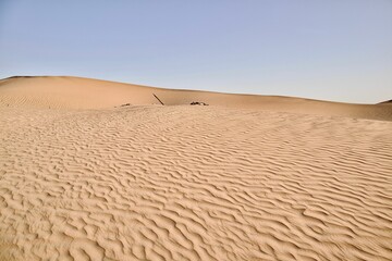 Scenic view of desert against sky under the clear blue sky with the sun shining bright