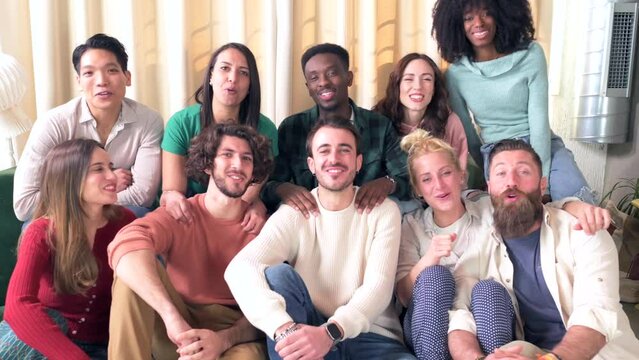 Young friends who sing best wishes, ten people on a couch celebrating a person looking at the camera singing and cheering
