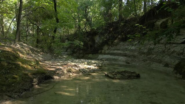 Beautiful view of woods in Lost Creek in Allen TX with river, rocks and light falling from trees