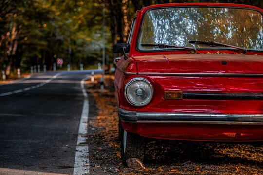 Retro ZAZ-968 car in the side asphalt road with autumn leaves