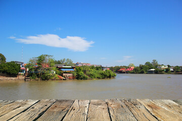 Fototapeta premium Wooden floor on the river with blue sky background, Wooden table, Thailand.