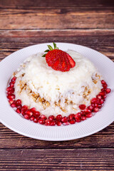 Güllaç dessert with pomegranate and strawberry. Ramadan dessert. Gullac dessert with walnuts on wooden background. Close up