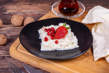 Güllaç dessert with pomegranate and strawberry. Ramadan dessert. Gullac dessert with walnuts on wooden background.