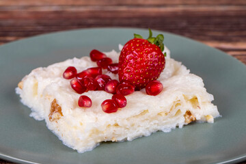 Güllaç dessert with pomegranate and strawberry. Ramadan dessert. Gullac dessert with walnuts on wooden background. Close up