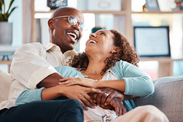 Love, happy and couple laugh on sofa for bonding, quality time and relaxing together at home. Marriage, relationship and black man and woman on couch embrace, hugging and laughing for funny joke