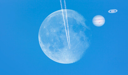 Jupiter-Saturn Convergence That Happens Every 20 Years, full moon in the foreground -  Trail of white smoke from the airplane on the blue sky 