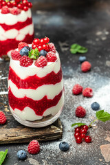 Raspberry dessert cheesecake, trifle, mouse in a glass. Raspberry Greek yogurt granola parfait on a dark background. Restaurant menu, dieting, cookbook recipe
