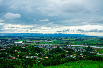 Fototapeta premium Stunning aerial view over town of Whakatane. The heart of the Eastern Bay of Plenty, New Zealand, it's nested between Whakatane River and bush-clad cliffs. Kohi Point Lookout, Whakatane, New Zealand