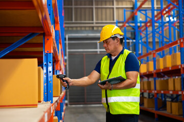 Warehouse manager staff working on barcode scanner handheld at warehouse factory. Trainee learning on the job