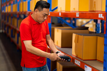 Warehouse manager staff working on barcode scanner handheld at warehouse factory. Trainee learning on the job