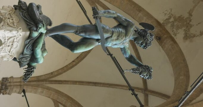 Vertical shot of Perseus with the head of Medusa statue, circle pan, low angle