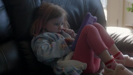 Female child playing and learning on a tablet at home - Powered by Adobe