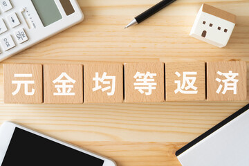 元金均等返済と書かれたブロック、電卓、スマホ、家のオブジェ、ノート