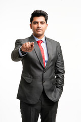 Young indian businessman pointing in front off with finger.