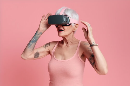 Portrait of smiling modern stylish senior woman in VR glasses against pink background.