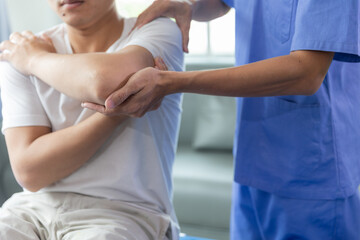 Doctor or Physiotherapist working examining treating injured arm of athlete male patient, stretching and exercise, Doing the Rehabilitation therapy pain in clinic. - obrazy, fototapety, plakaty