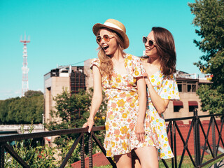 Two young beautiful smiling hipster female in trendy summer dresses  clothes. Sexy carefree women...