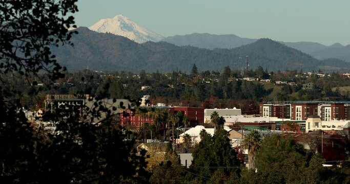 Afternoon snow covered view of the peak of Mount Shasta and the downtown skyline of Redding, California, USA.