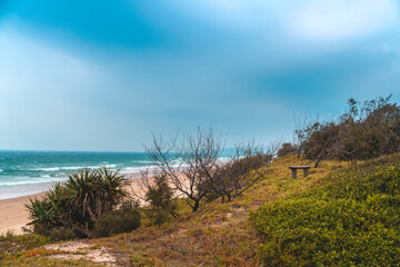 Fototapeta na wymiar Spectacular panoramic view of the Peregian beach with Pacific ocean waves crushing on the shore visible from the green hill on a bright sunny day on Sunshine Coast, Queensland, Australia.