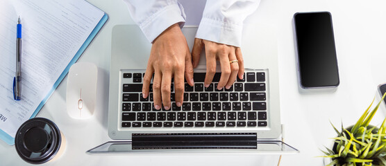 Doctor Day Concept. Nurse working using computer browsing internet, female doctor wear uniform in hospital typing information on keyboard laptop, Healthcare medical website technology online