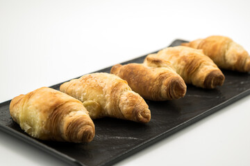 Traditional rolled dough called Kiflice served on black plate and white background