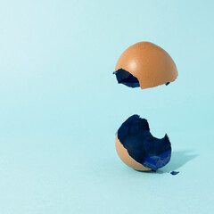 Broken easter eggs on blue background. Creative eggshell with copy space. Minimal Easter holiday concept.