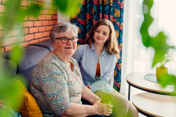 Different generation concept.Happy grandmother and granddaughter are sitting together, cozy home...